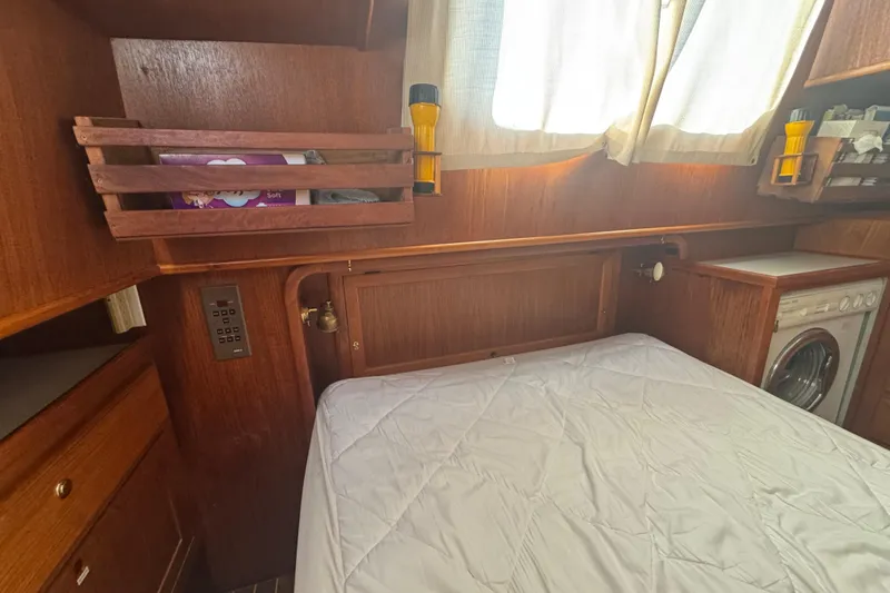 Slide: The Image of Cozy cabin interior of 2001 Monk Trawler with bed, storage, and washing machine. - 87
