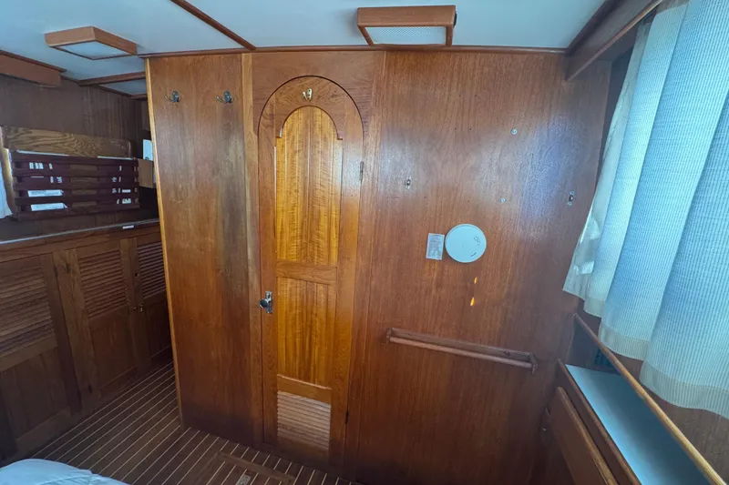 Slide: The Image of Wood-paneled interior of a 2001 Monk Trawler boat, featuring a door and curtains. - 88