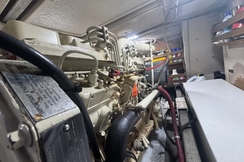 Slide: The Image of Engine room of a 2001 Monk Trawler, showcasing mechanical components and storage shelves. - 96