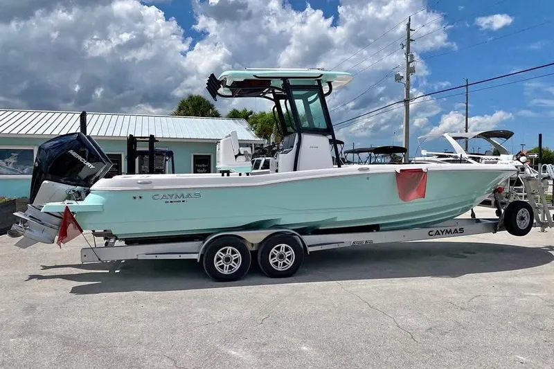 Slide: The Image of 2023 Caymas 281 HB boat on trailer, parked outdoors under cloudy sky. - 11