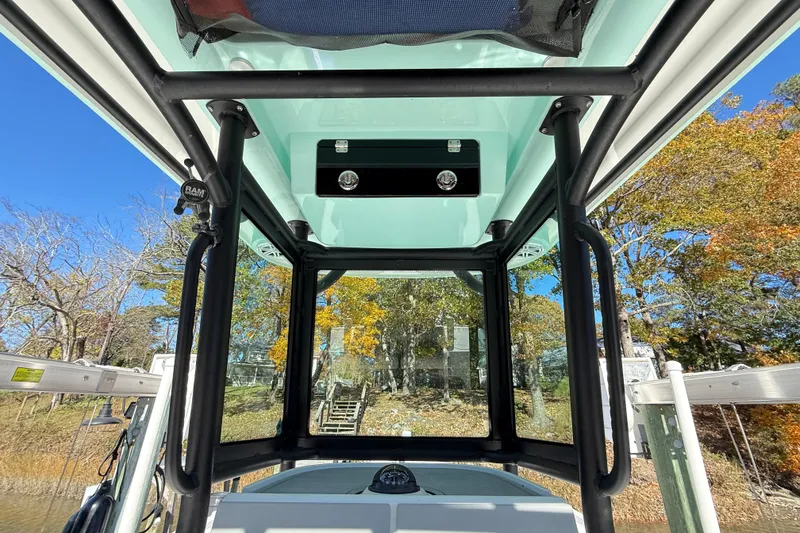 Slide: The Image of Interior view of 2023 Caymas 281 HB boat with clear canopy and scenic background. - 16