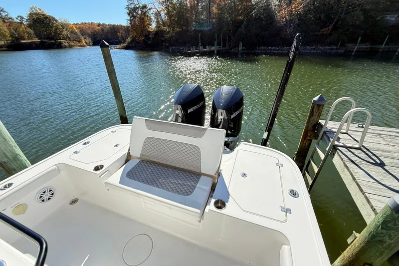 Slide: The Image of 2023 Caymas 281 HB boat with dual Mercury engines docked by a serene lake. - 17