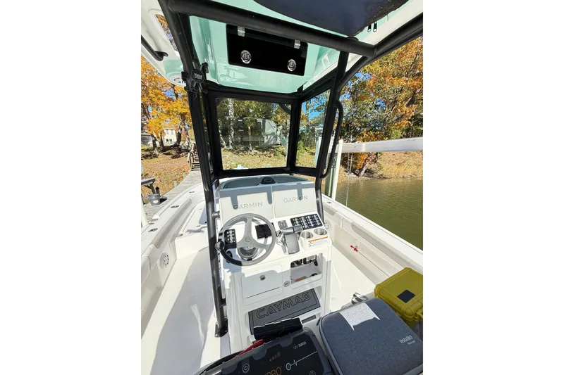 Slide: The Image of 2023 Caymas 281 HB boat cockpit with Garmin navigation, surrounded by autumn foliage. - 37