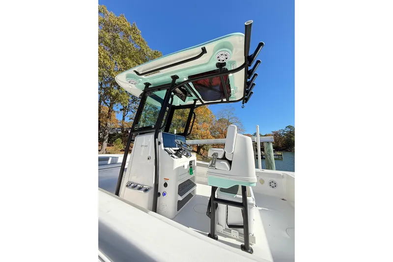 Slide: The Image of 2023 Caymas 281 HB boat interior with helm station and seating, under clear blue sky. - 42