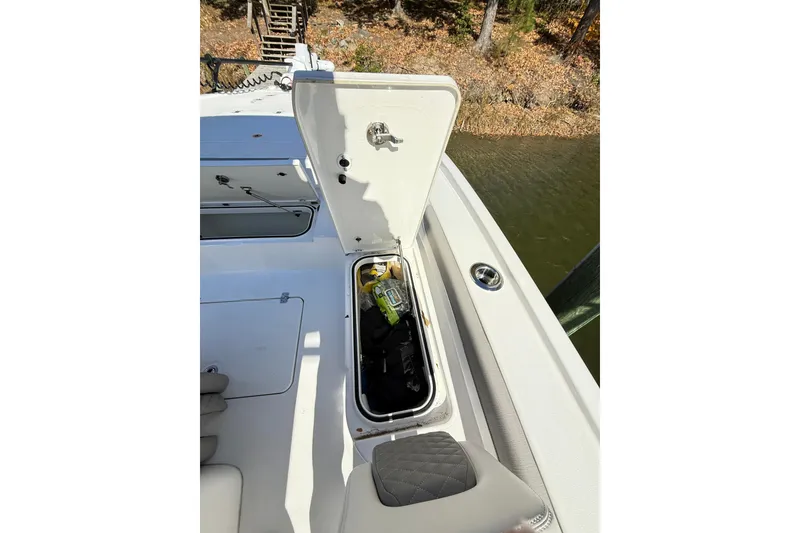 Slide: The Image of 2023 Caymas 281 HB boat storage compartment open by the water. - 51
