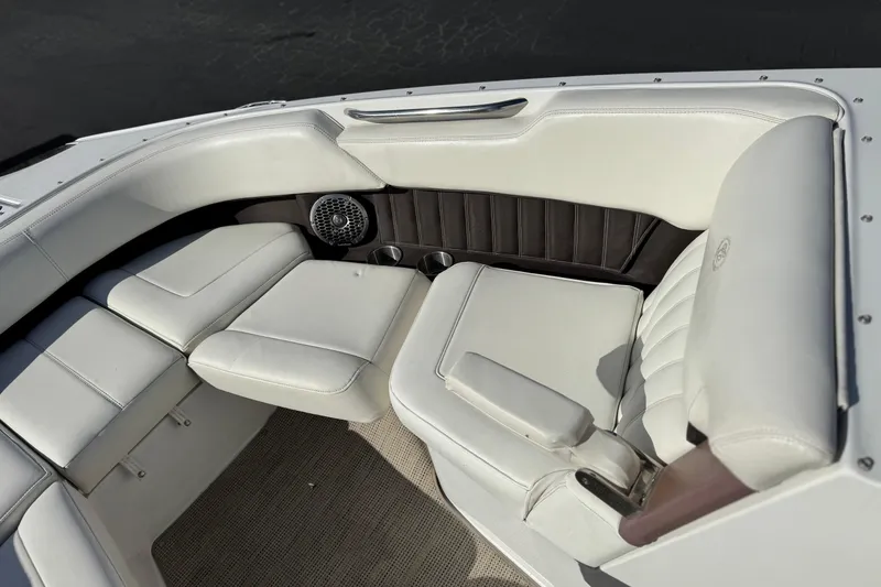 Slide: The Image of 2014 Cobalt 24SD boat interior with white leather seating and speaker detail. - 19