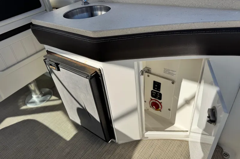 Slide: The Image of 2014 Cobalt 24SD boat interior with sink, storage, and control panel. - 28
