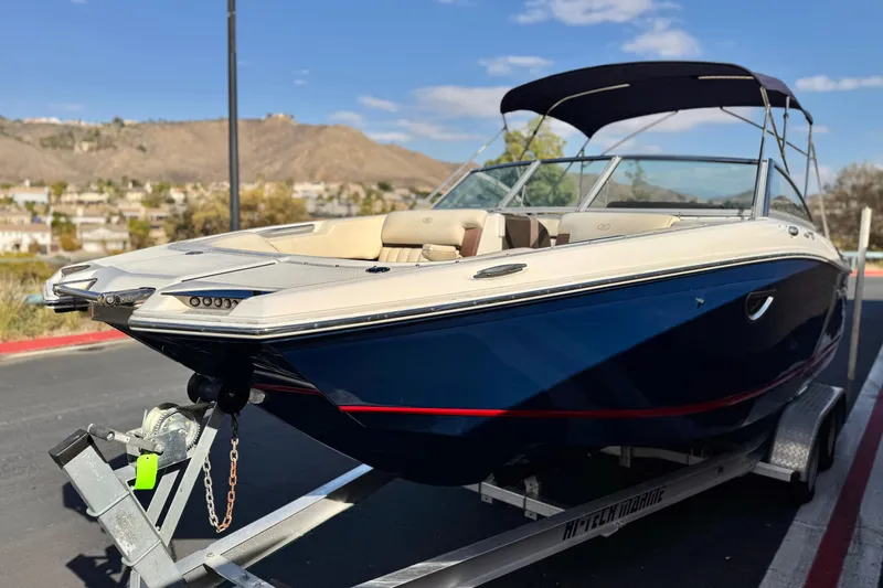 Slide: The Image of 2014 Cobalt 24SD boat on trailer, blue hull, beige interior, sunny day. - 3