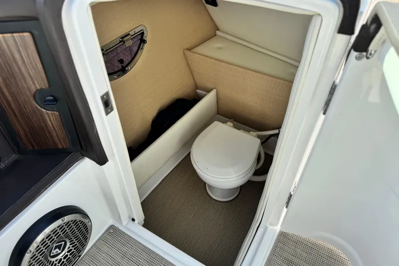 Slide: The Image of 2014 Cobalt 24SD boat interior with compact marine toilet and storage area. - 32