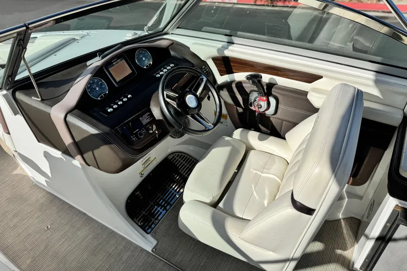 Slide: The Image of Interior of a 2014 Cobalt 24SD boat featuring a sleek dashboard and comfortable seating. - 35