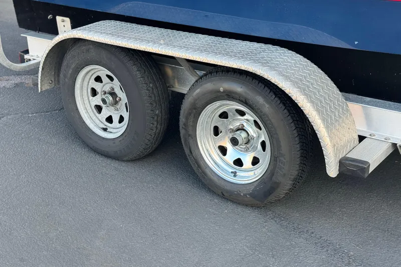 Slide: The Image of Trailer wheels and fender of a 2014 Cobalt 24SD boat on pavement. - 38