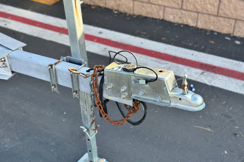 Slide: The Image of Trailer hitch of a 2014 Cobalt 24SD with safety chains on asphalt. - 39