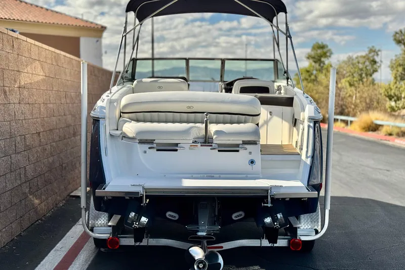 Slide: The Image of 2014 Cobalt 24SD boat with seating, parked outdoors under a cloudy sky. - 4