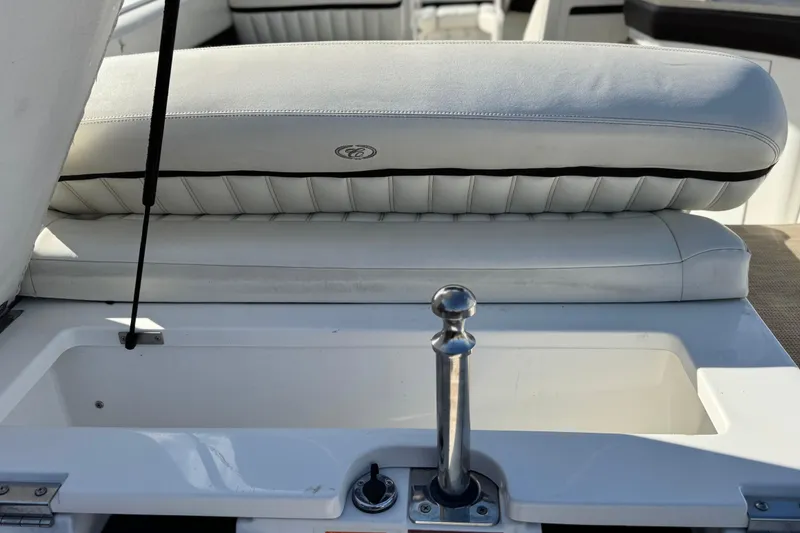 Slide: The Image of 2014 Cobalt 24SD boat interior with white cushioned seating and storage compartment. - 8