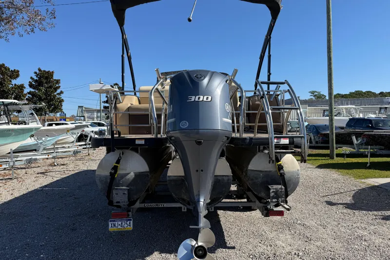 Slide: The Image of 2022 Godfrey Monaco 255 SFL pontoon boat cruising on a serene lake. - 6