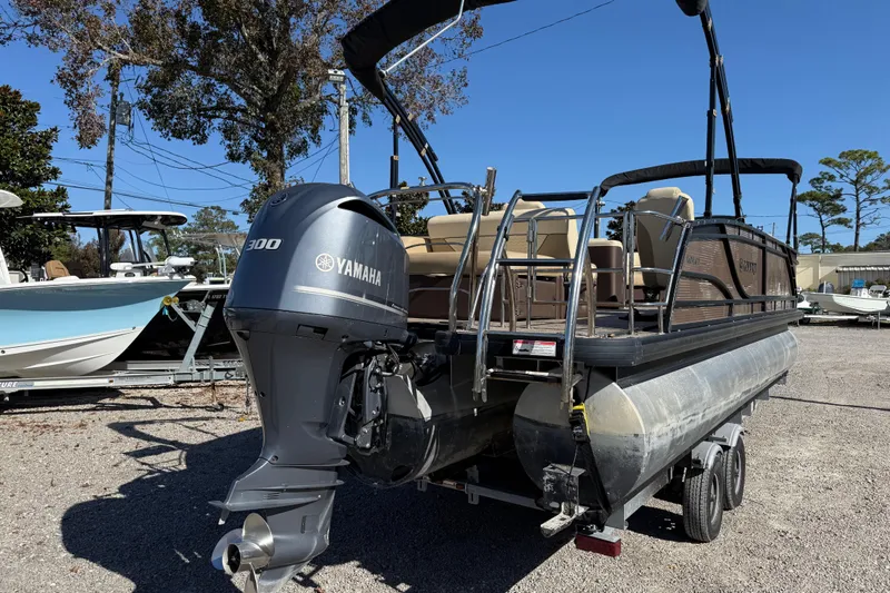 Slide: The Image of 2022 Godfrey Monaco 255 SFL pontoon boat cruising on a serene lake. - 7