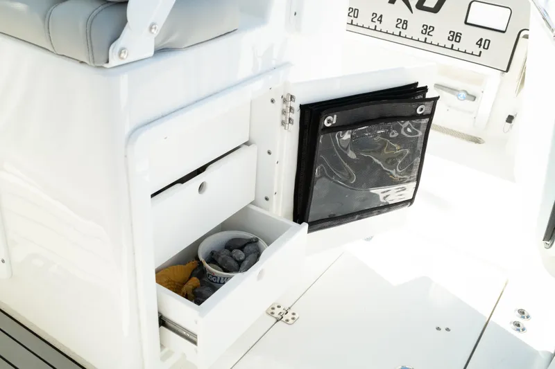 Slide: The Image of 2019 Sea Pro 259 Center Console storage compartment with open drawers and fishing gear. - 23