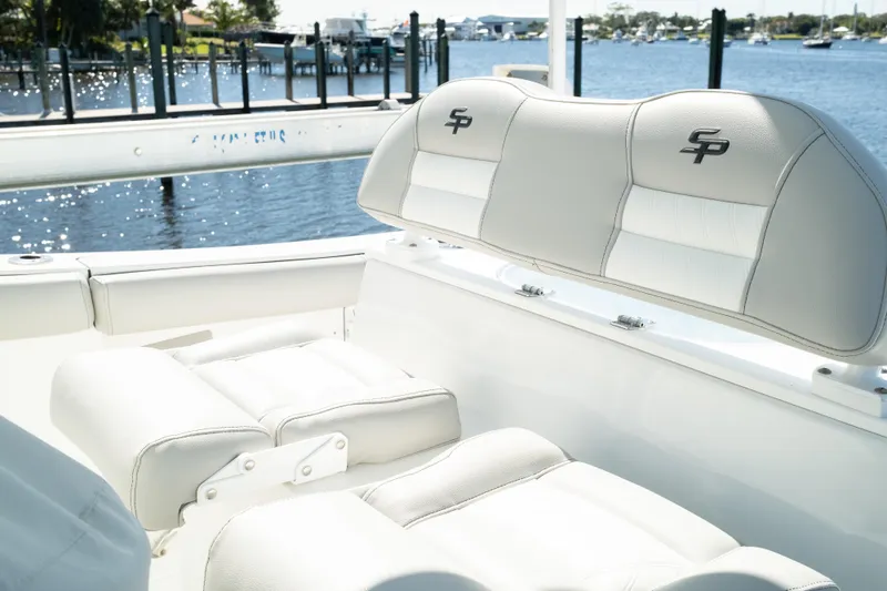 Slide: The Image of 2019 Sea Pro 259 Center Console boat with white seating, docked by a scenic waterfront. - 25