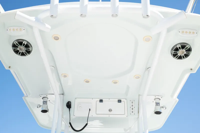 Slide: The Image of 2019 Sea Pro 259 Center Console boat roof with speakers and lights against blue sky. - 29
