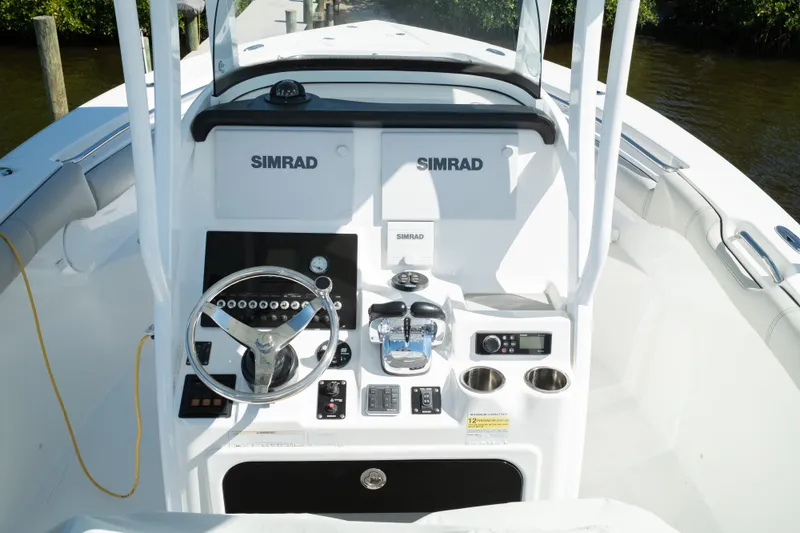 Slide: The Image of 2019 Sea Pro 259 Center Console boat dashboard with Simrad electronics and steering wheel. - 31