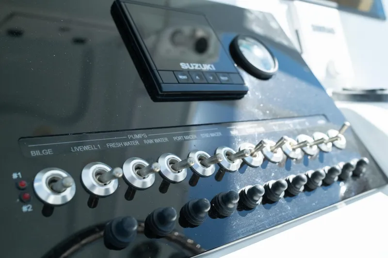 Slide: The Image of 2019 Sea Pro 259 Center Console dashboard with Suzuki controls and switches. - 34