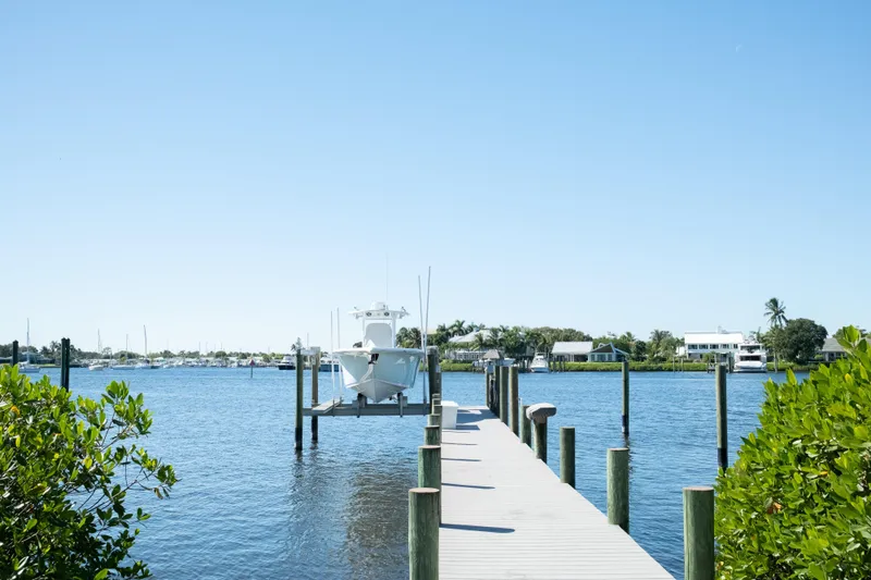 Slide: The Image of 2019 Sea Pro 259 Center Console boat docked on a sunny waterfront pier. - 59
