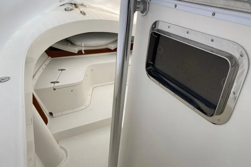 Slide: The Image of Interior view of a 2007 Roth Bilt 24 CC boat, featuring a sleek white cabin design. - 14