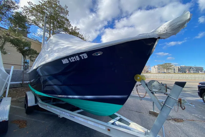 Slide: The Image of 2007 Roth Bilt 24 CC boat moored in a scenic harbor with clear skies. - 2