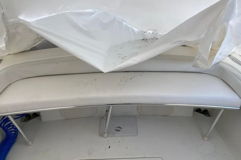 Slide: The Image of 2007 Roth Bilt 24 CC boat interior with white seating and protective cover. - 25