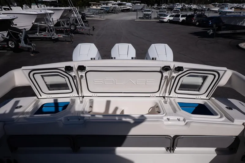 Slide: The Image of 2026 Solace 37 Pilot boat with open storage compartments and triple engines in a marina. - 18