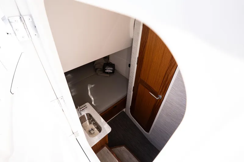 Slide: The Image of Interior cabin view of 2026 Solace 37 Pilot boat, featuring a compact sink and wooden door. - 35