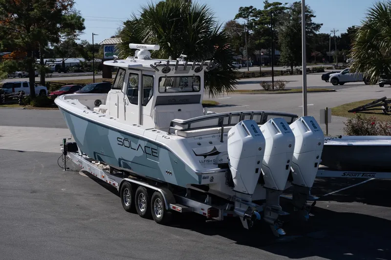 Slide: The Image of 2026 Solace 37 Pilot boat on trailer with triple engines, parked outdoors. - 5