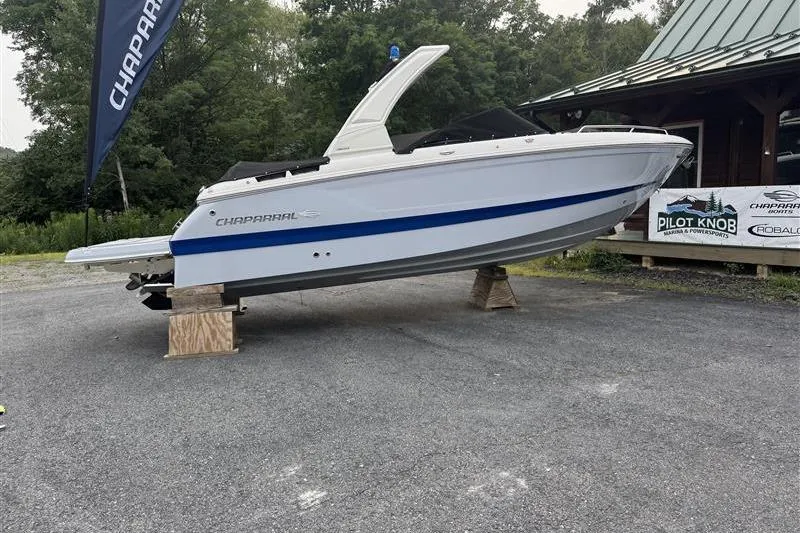The Image of 2025 Chaparral 267 SSX boat displayed outdoors on wooden supports. - 0