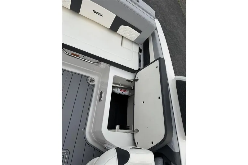 Slide: The Image of 2025 Chaparral 267 SSX boat interior storage compartment with open hatch. - 15