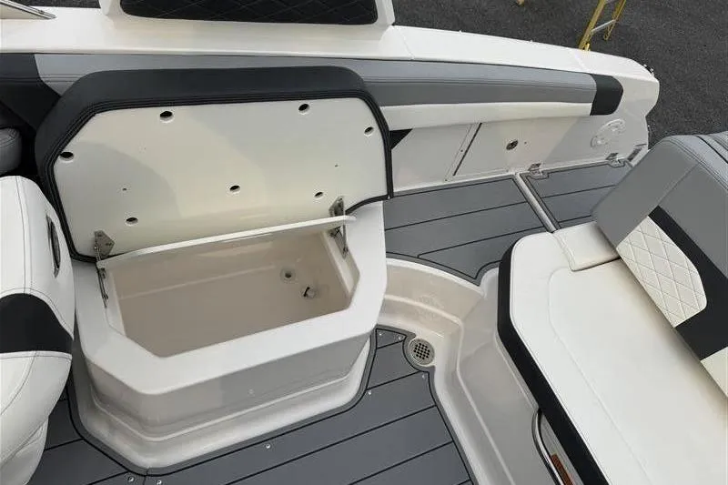 Slide: The Image of 2025 Chaparral 267 SSX boat interior with open storage compartment and seating. - 19