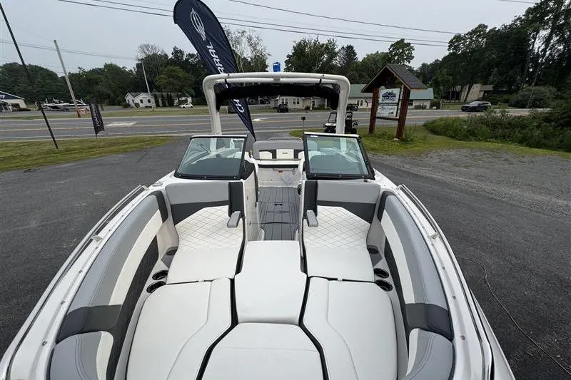 Slide: The Image of 2025 Chaparral 267 SSX boat with spacious seating and sleek design, parked outdoors. - 20