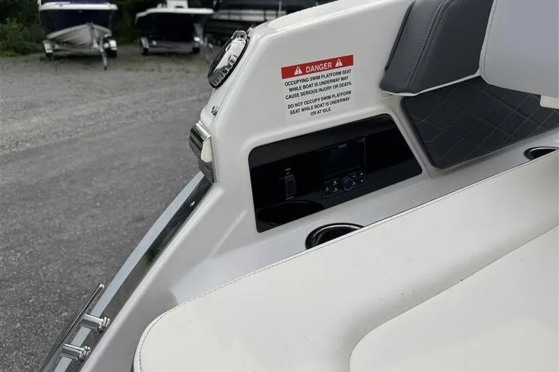 Slide: The Image of 2025 Chaparral 267 SSX boat interior with warning label and seating area. - 22