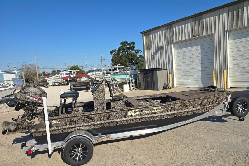 Slide: The Image of 2026 Pro-Drive 1856 SBX TD boat on trailer, parked outside a warehouse. - 3