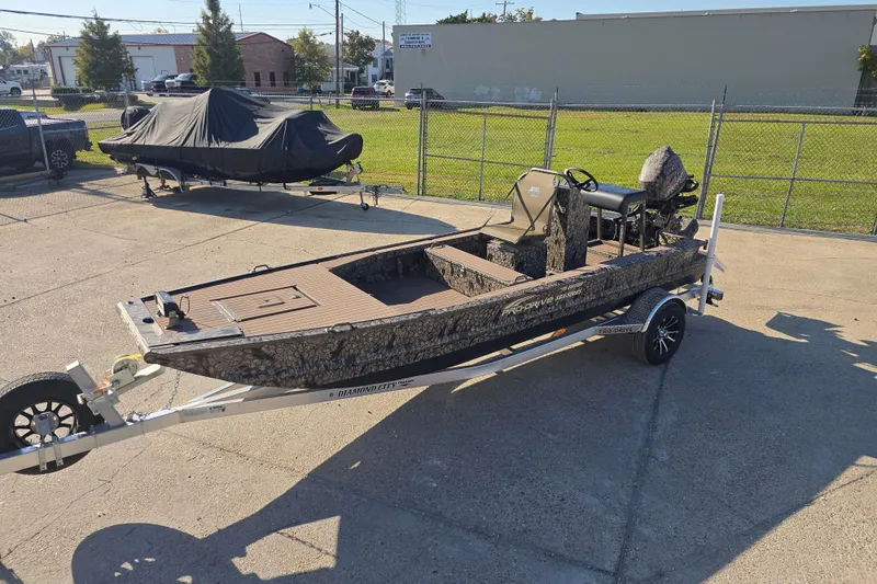 Slide: The Image of 2026 Pro-Drive 1856 SBX TD boat on trailer, camo design, parked outdoors. - 8