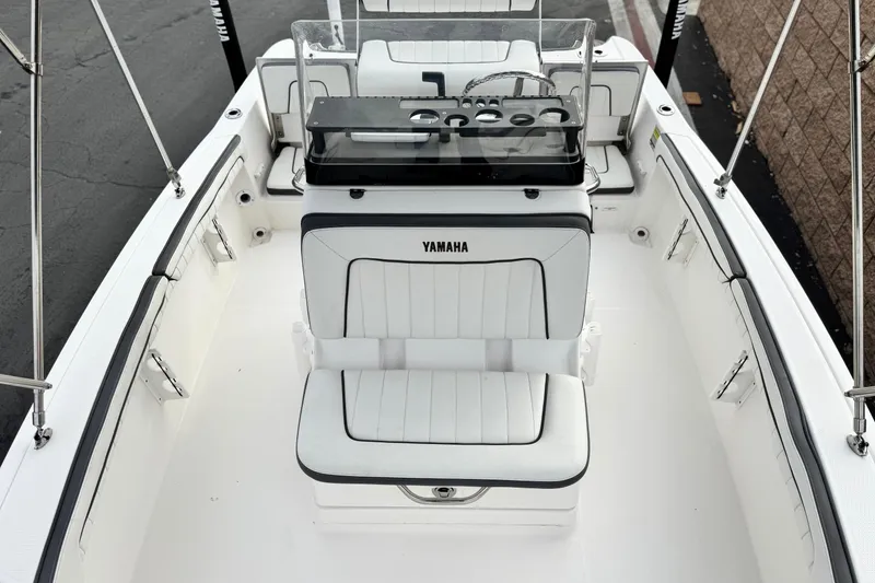 Slide: The Image of 2016 Yamaha Boats 190 FSH Deluxe interior with white seating and console. - 16