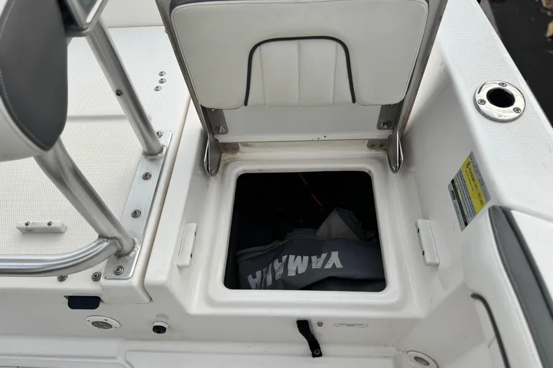 Slide: The Image of Open storage compartment on a 2016 Yamaha Boats 190 FSH Deluxe, featuring a Yamaha bag. - 25