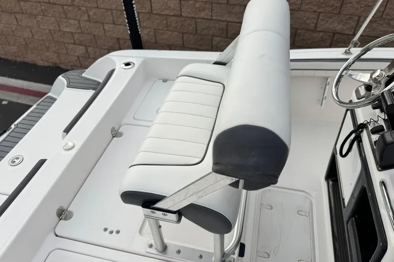 Slide: The Image of 2016 Yamaha Boats 190 FSH Deluxe interior with white seating and steering console. - 28
