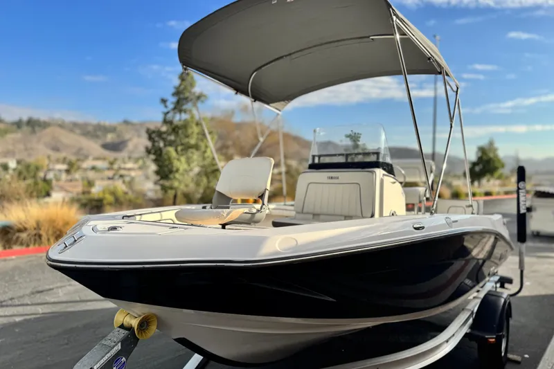 Slide: The Image of 2016 Yamaha Boats 190 FSH Deluxe with canopy, parked outdoors on a sunny day. - 3