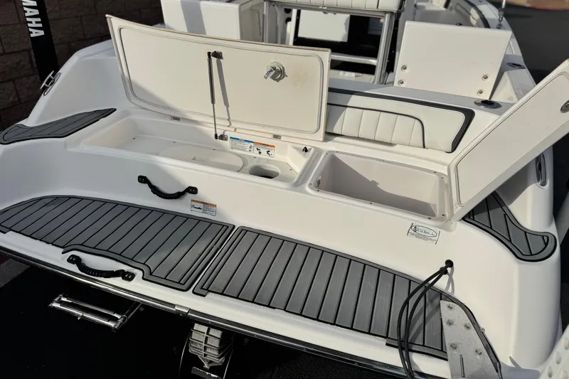 Slide: The Image of 2016 Yamaha Boats 190 FSH Deluxe, open storage compartments, sleek design, rear view. - 7