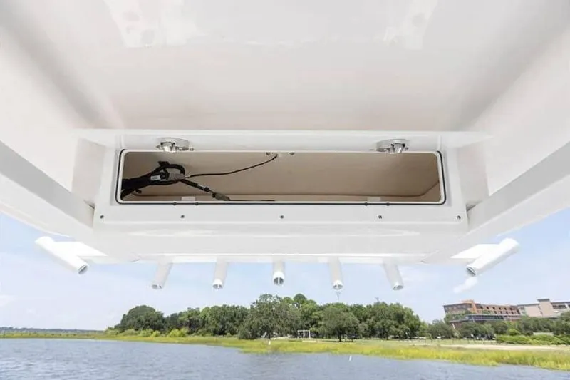 Slide: The Image of 2024 Sea Fox 231 Bay Fox boat storage compartment with scenic water and greenery background. - 10