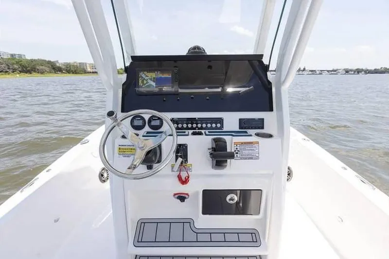Slide: The Image of 2024 Sea Fox 231 Bay Fox boat console with steering wheel and controls on open water. - 12