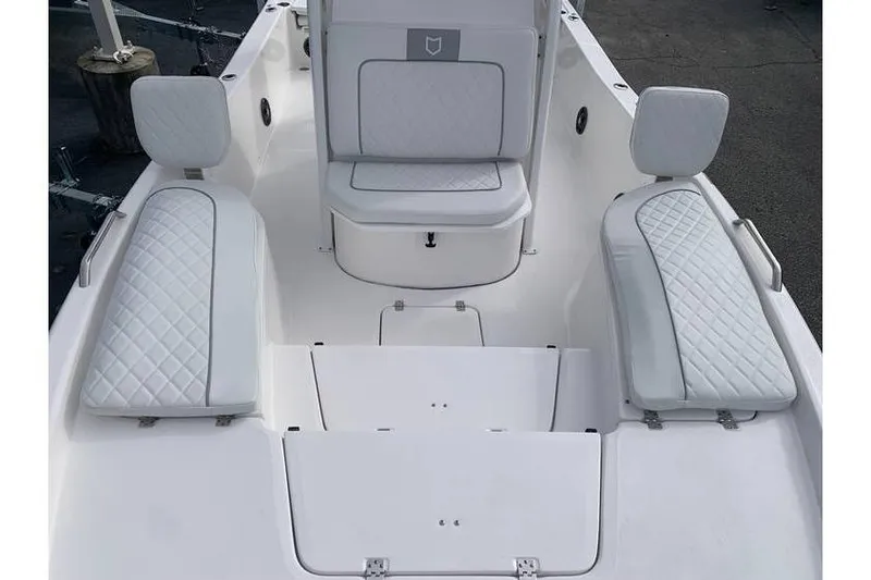 Slide: The Image of 2024 Sea Fox 231 Bay Fox boat interior with white cushioned seating and storage compartments. - 20