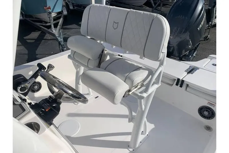Slide: The Image of 2024 Sea Fox 231 Bay Fox boat helm with cushioned seating and steering wheel. - 21