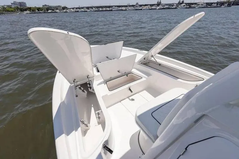 Slide: The Image of 2024 Sea Fox 231 Bay Fox boat with open storage compartments on calm water. - 8