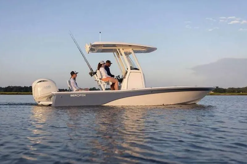 Slide: The Image of 2024 Sea Fox 231 Bay Fox boat on calm water, featuring anglers and fishing gear. - 9